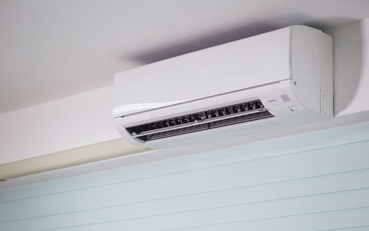 Wandh&auml;ngendes Innenger&auml;t einer Split-Klimaanlage mit ge&ouml;ffneten Luftlamellen unter einer hellen Decke.