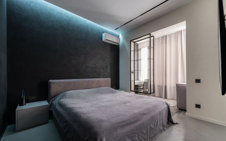 Schlafzimmer mit wandh&auml;ngendem Split-Innenger&auml;t &uuml;ber dem Bett, indirekt beleuchtete Decke.