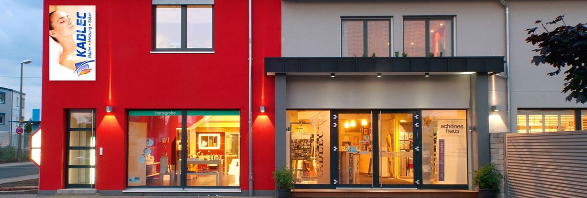 Das Ladengeschäft der Kadlec GmbH in Bad Kreuznach am Abend: rote Fassade mit KADLEC-Schild, beleuchtete Ausstellungsräume hinter großen Schaufenstern.